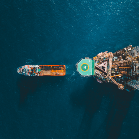 Aerial view of a supply vessel alongside an offshore platform with helideck, showing hydraulic equipment used in offshore operations